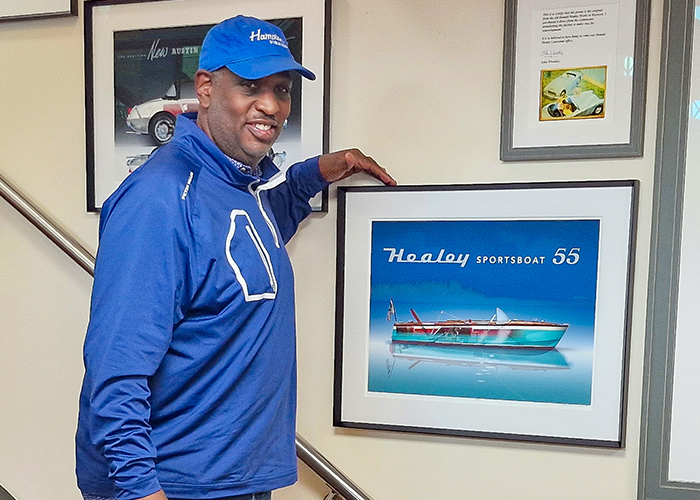 Ken Flemming standing next to the print of his Healey 55 Sportsboat